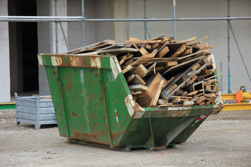 Green skip filled with wood waste
